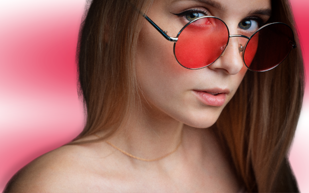 Ragazza con capelli castani lunghie, indossa occhiali con lenti rosse